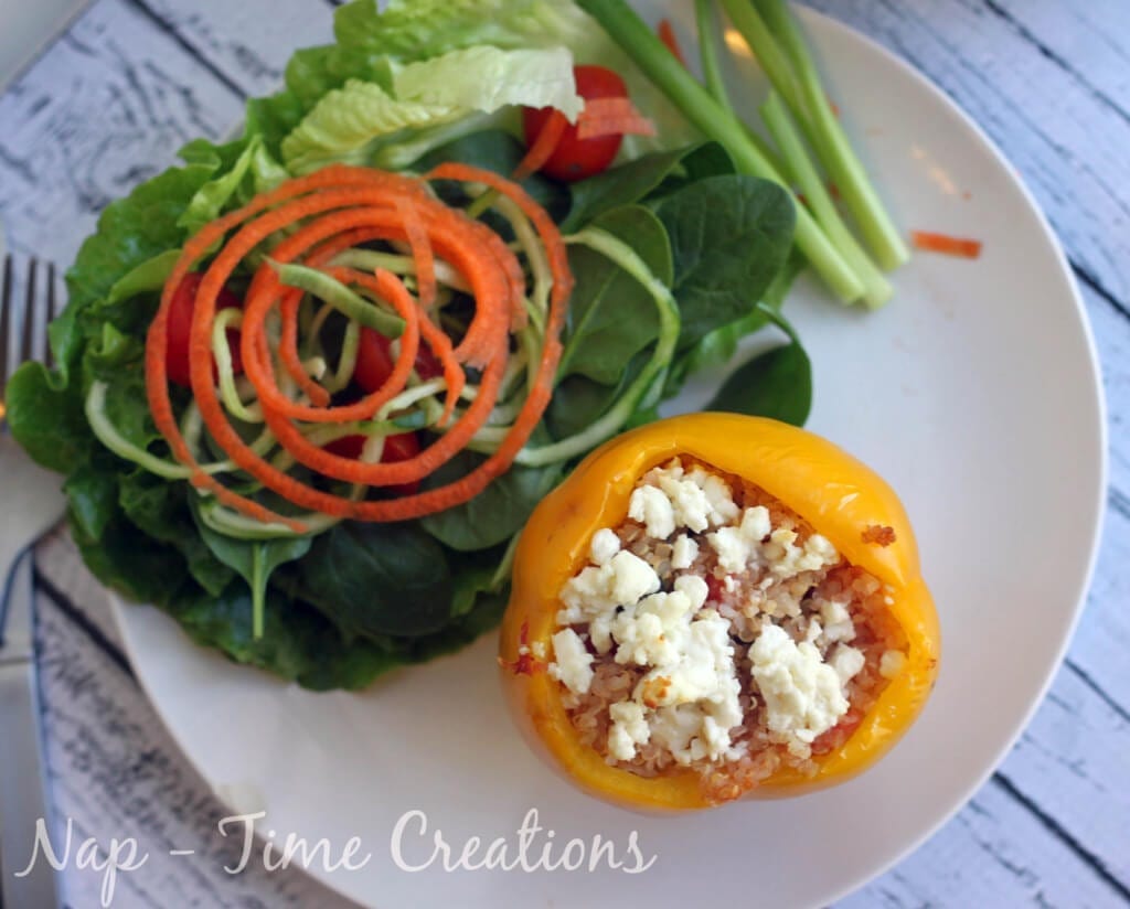 Sausage Stuffed Peppers with Feta on a plate with fresh vegetables.