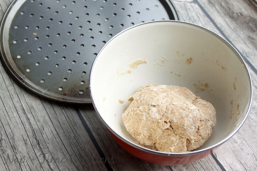 Whole Wheat Pizza being mixed up with the dough inside of a mixing bowl.